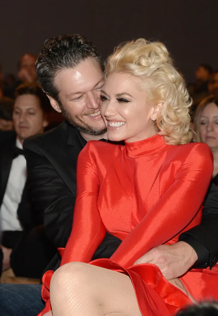 Recording artists Blake Shelton and Gwen Stefani embracing and smiling at the 2016 Pre-GRAMMY Gala.