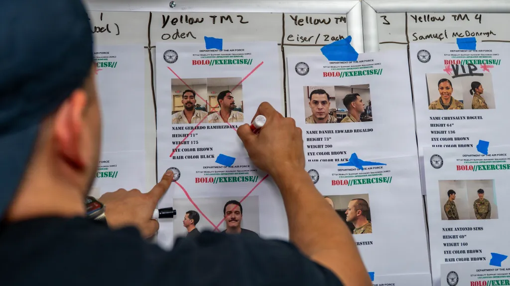 A U.S. Air Force Air Advisor crosses out a picture of a captured Airman on a "BOLO Exercise" sheet during Exercise Sourdough.