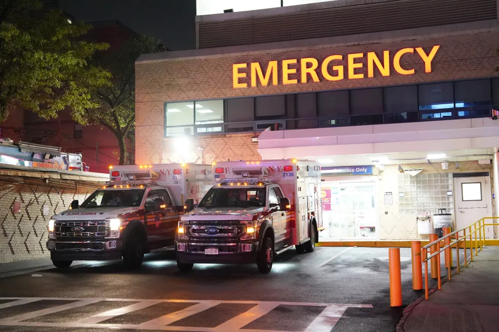 Two FDNY ambulances parked outside the Montefiore Medical Center Wakefield Campus emergency room at night.