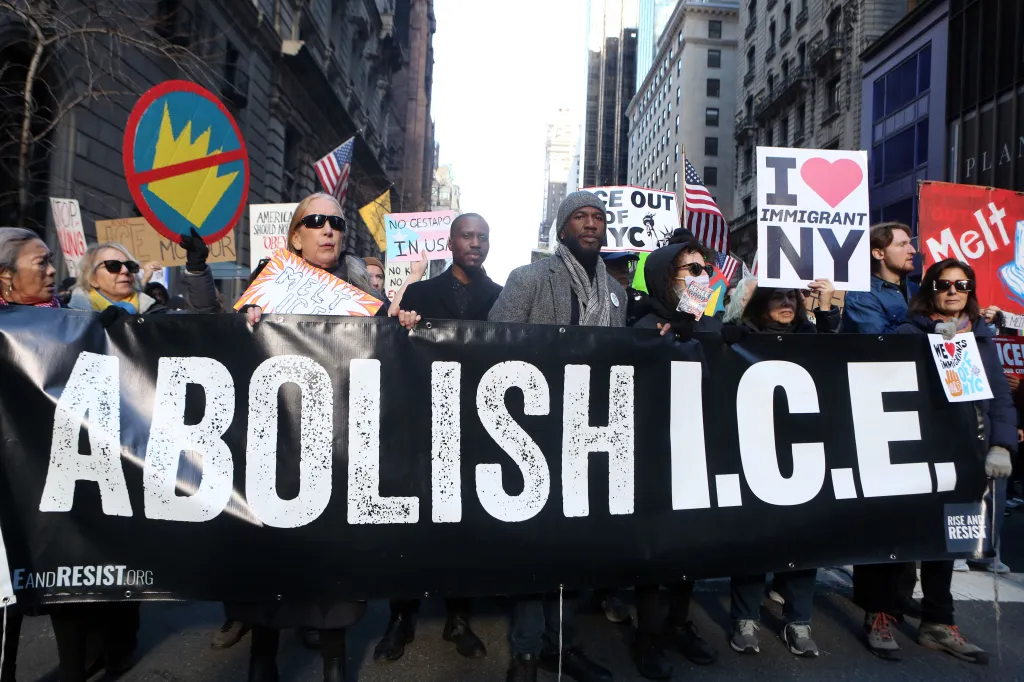 Demonstrators holding a large "ABOLISH I.C.E." banner during a protest in New York City.