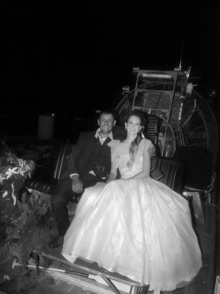 Lana Del Rey and Jeremy Dufrene seated on an airboat.