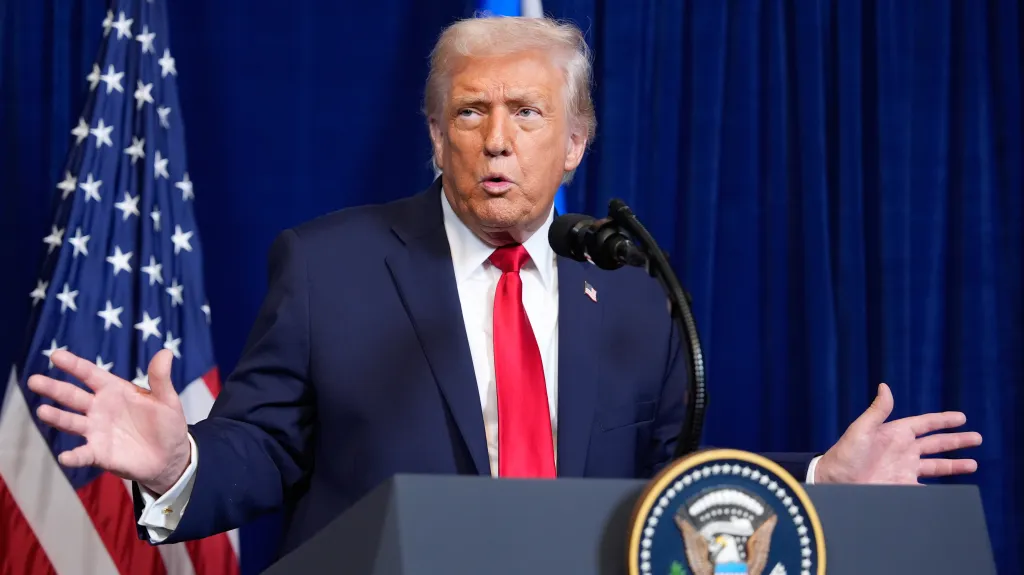 President Donald Trump speaks at a news conference, gesturing with his hands.