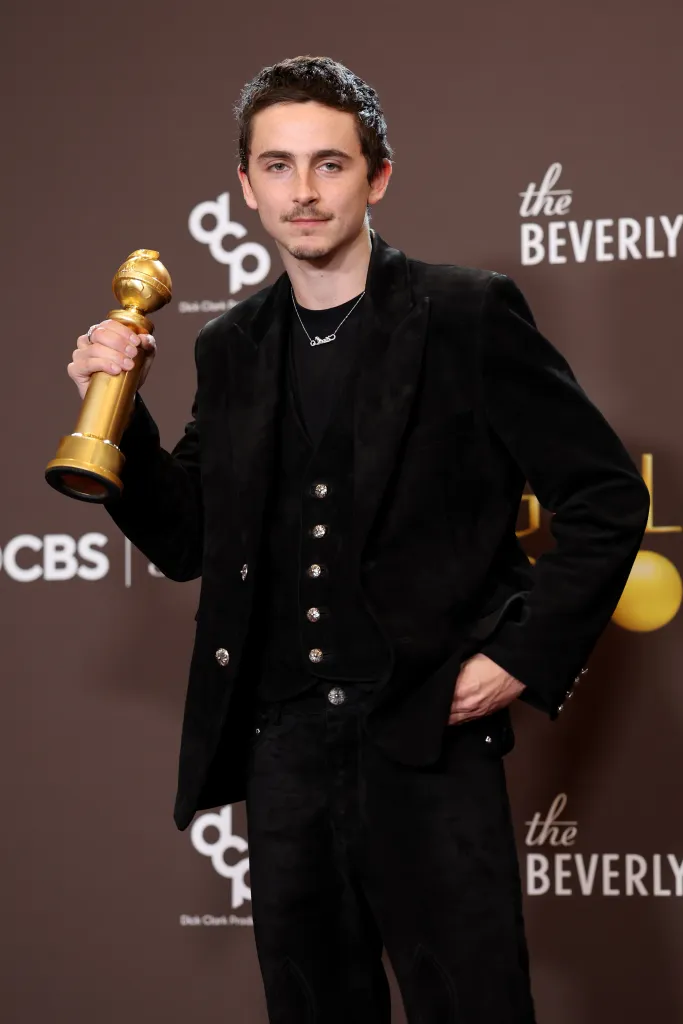 Timothée Chalamet posing with his Golden Globe Award.