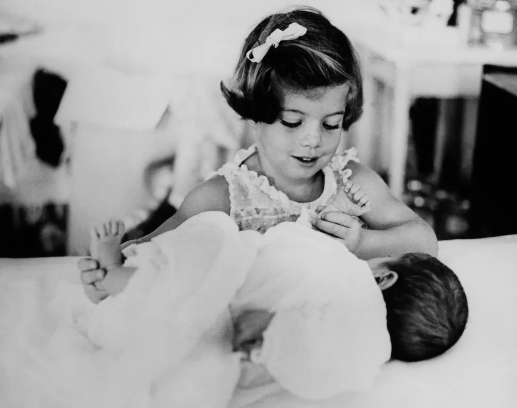 Caroline Kennedy holding her baby brother, John F. Kennedy Jr.