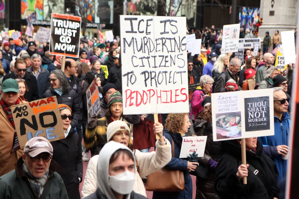 Protesters hold signs during a "No Kings" protest in New York City.