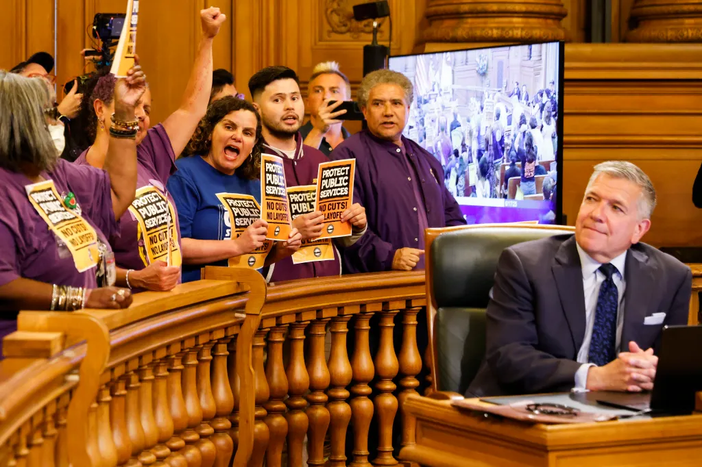 Workers protest budget cuts and layoffs at a San Francisco Supervisors meeting.