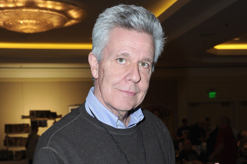 Headshot of actor Barry Bostwick wearing a brown sweater over a blue shirt.