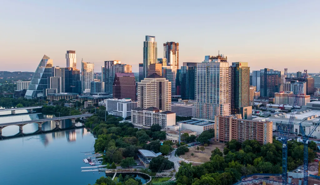 Austin, Texas skyline at sunrise with the city reflecting on the river.