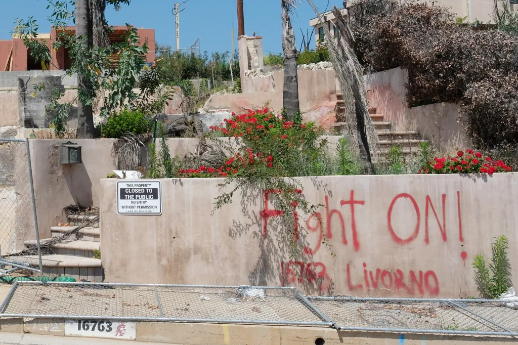 A property that appears to be under construction with a sign that reads "THIS PROPERTY CLOSED TO THE PUBLIC NO ENTRY WITHOUT PERMISSION" and "Fight ON! Livorno" spray-painted in red.
