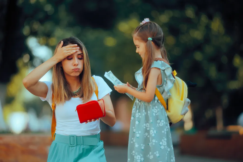 A mother looks frustrated, holding an empty wallet, while her daughter holds money.
