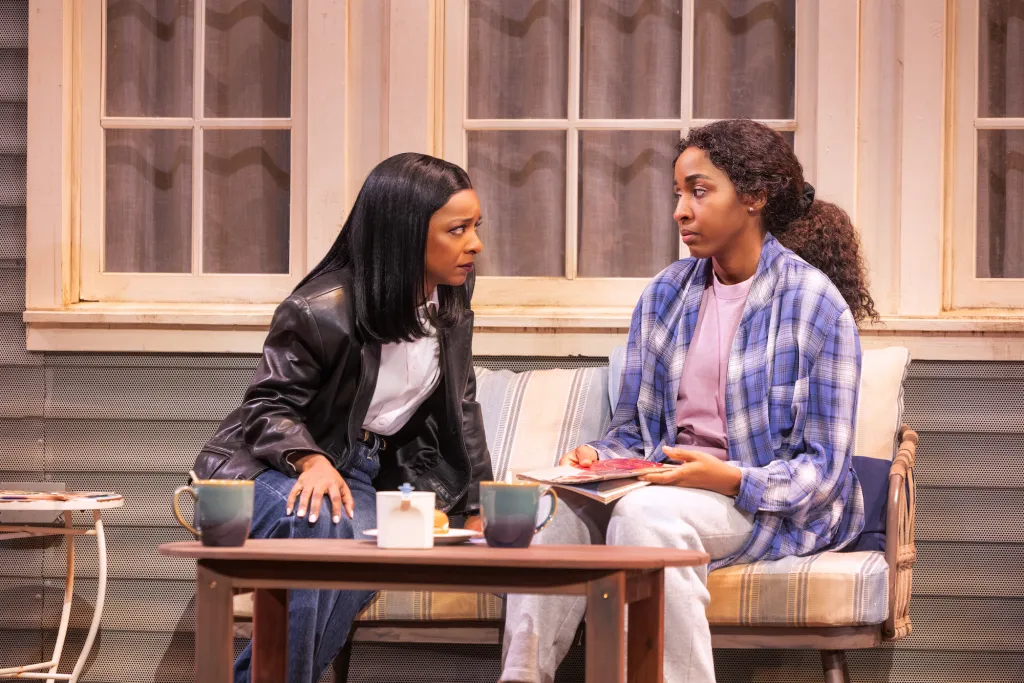 Two women talking to each other on a porch