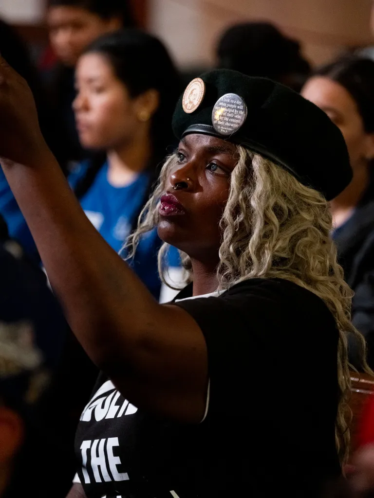 A woman wearing a beret with "I look to a day when people will not be judged by the color of their skin, but by the content of their character - Dr. Martin Luther King, Jr." pin on it.