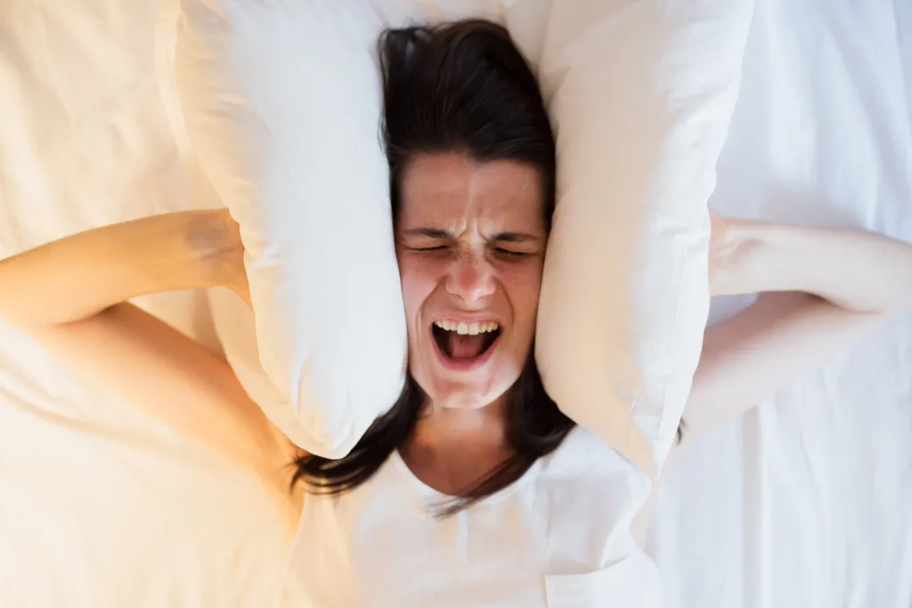 Annoyed woman covering her ears. 