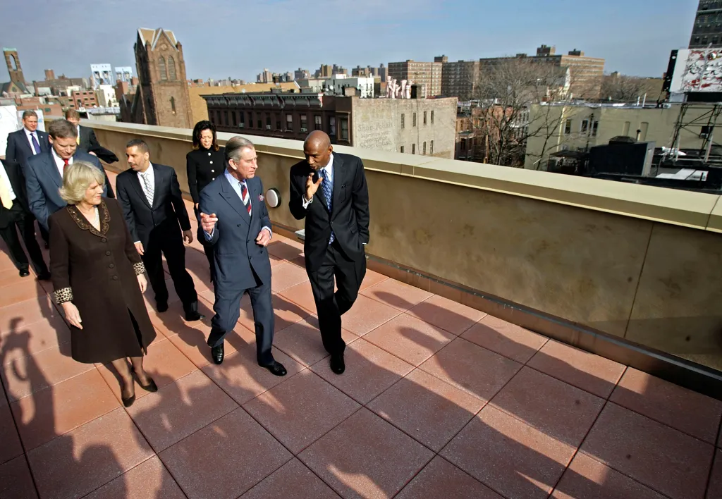 Prince Charles and Geoffrey Canada, along with other attendees, on a rooftop overlooking Harlem.