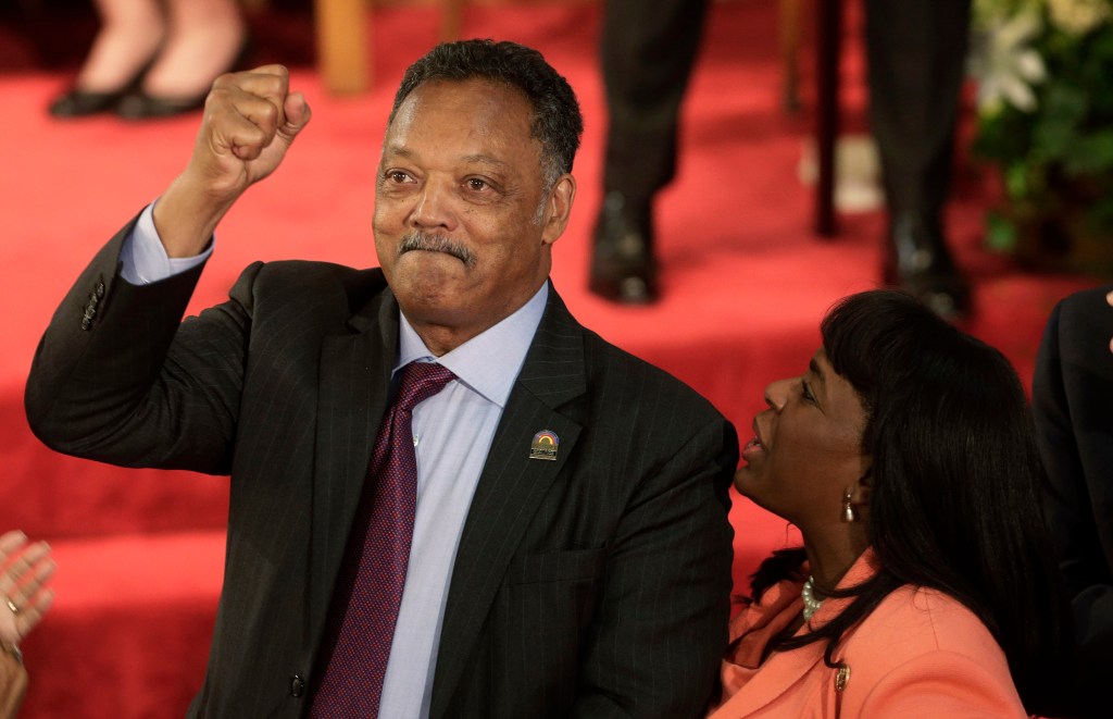 Rev. Jesse Jackson raising his fist while speaking to Rep. Terri Sewell at the 16th Street Baptist Church.