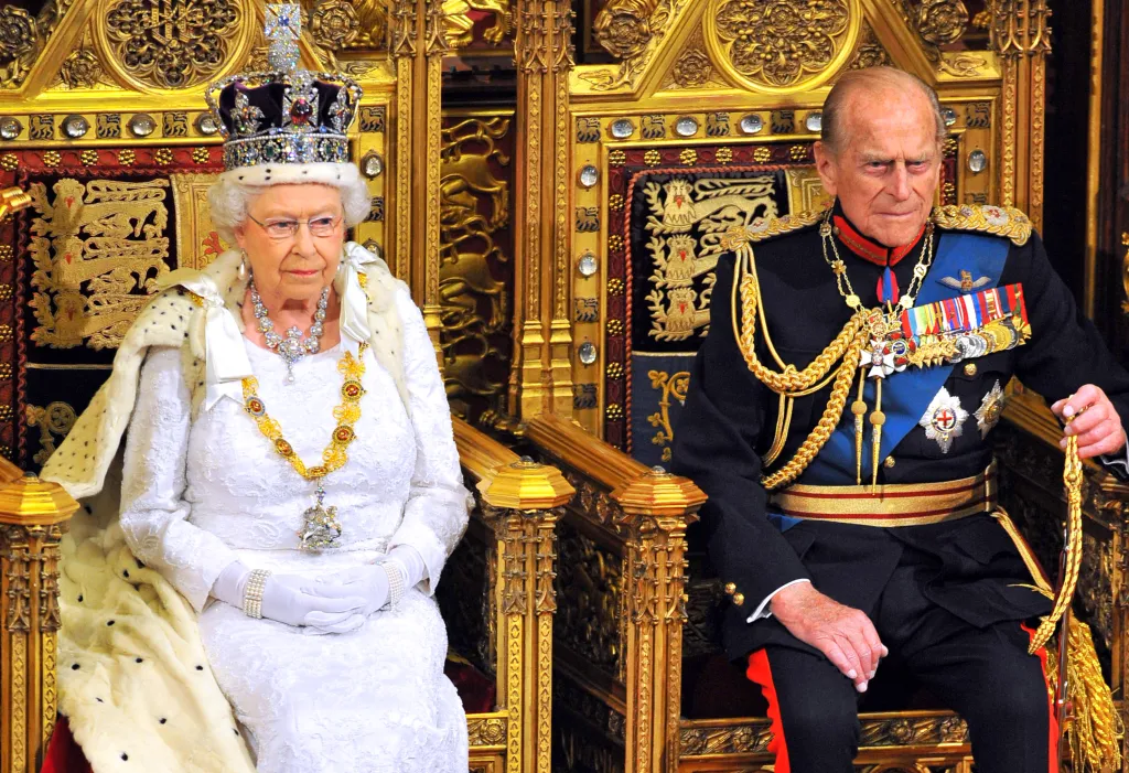 Queen Elizabeth II and Prince Philip sitting in ornate chairs during the State Opening of Parliament.