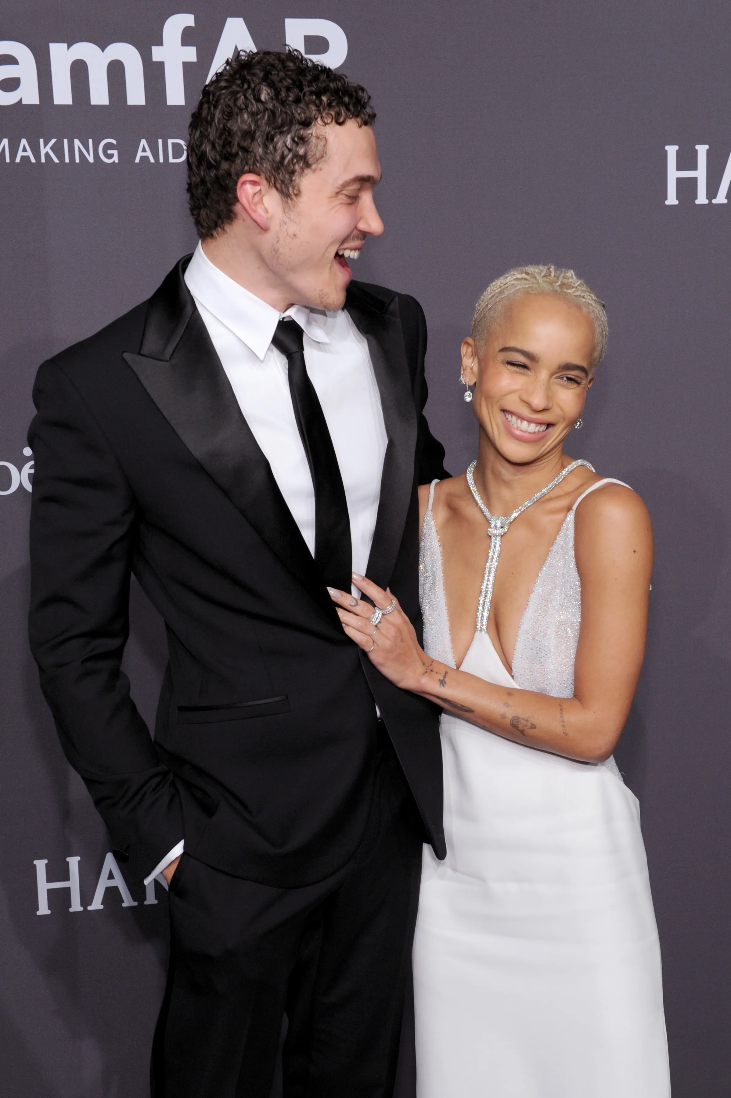Actor Karl Glusman and Model Zoe Kravitz smile at an event.