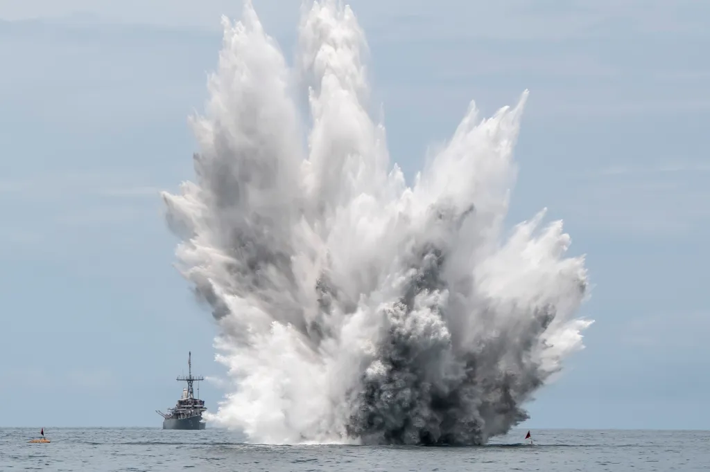The Avenger-class mine countermeasures ship USS Pioneer observes a controlled mine detonation exercise.