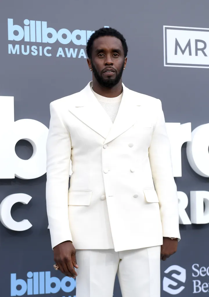Sean "Diddy" Combs posing in a white suit.