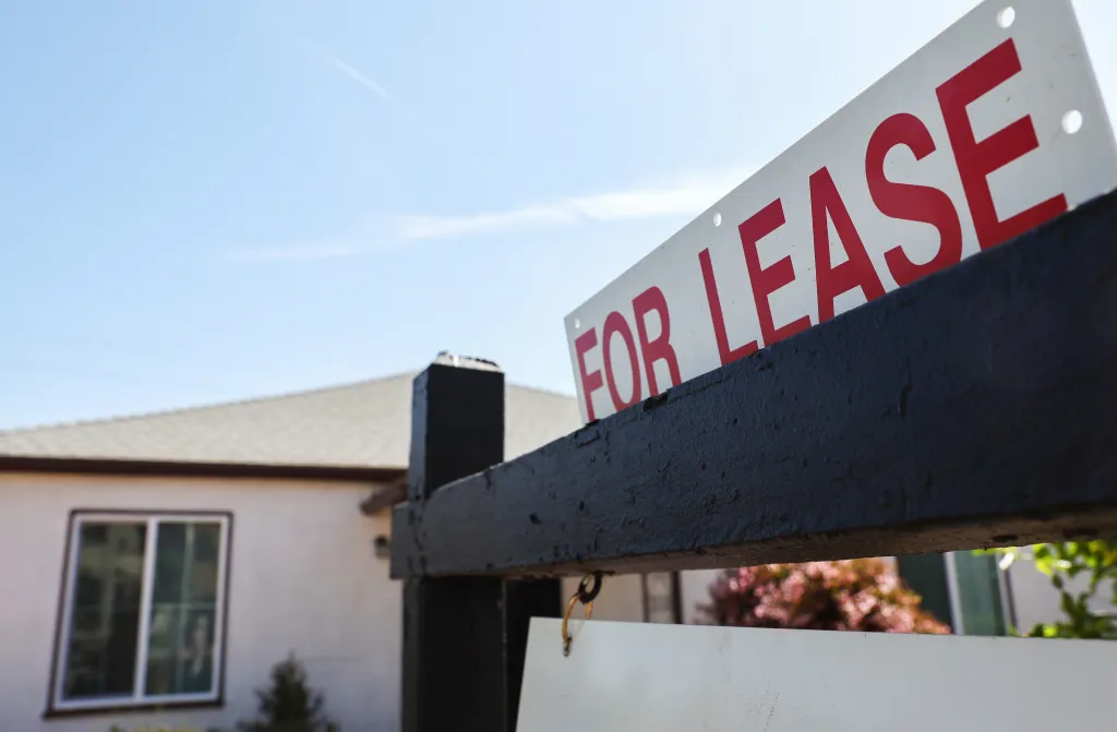 A "FOR LEASE" sign in front of a house.