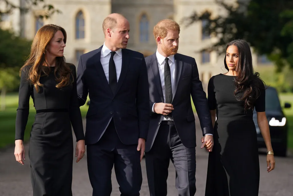 Prince William, in a black suit and black tie, Kate Middleton, in a black dress, walk with Prince Harry, in a black suit and black tie, and Meghan Markle, in a black dress.