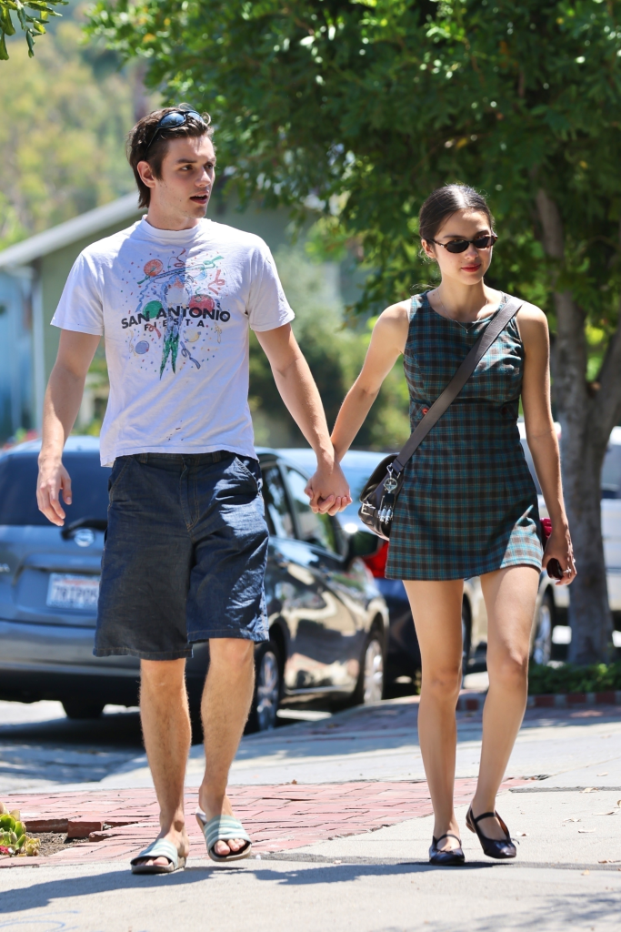 Olivia Rodrigo and Louis Partridge walking hand-in-hand.
