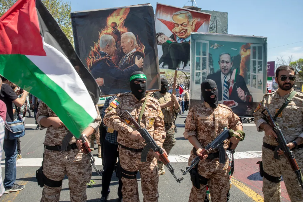 Armed men in camouflage and balaclavas, one holding a Palestinian flag, march alongside posters depicting caricatures of American and Israeli leaders.