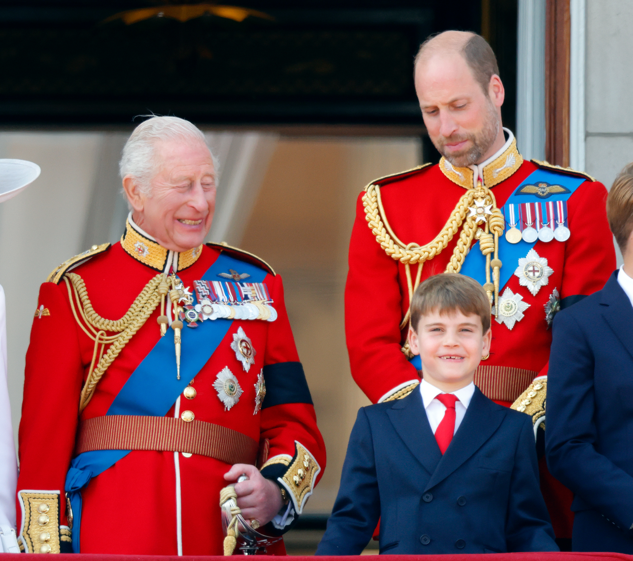 King Charles III, Prince Louis of Wales, and Prince William, Prince of Wales, watching an RAF flypast from the balcony of Buckingham Palace.