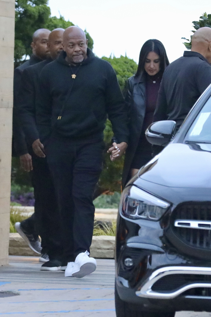 Dr. Dre and Michelle Saniei holding hands while leaving Nobu restaurant.