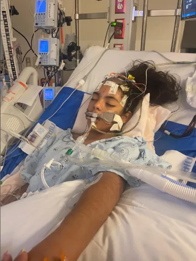 Khimberly Zavaleta Chuquipa in a hospital bed with medical equipment.