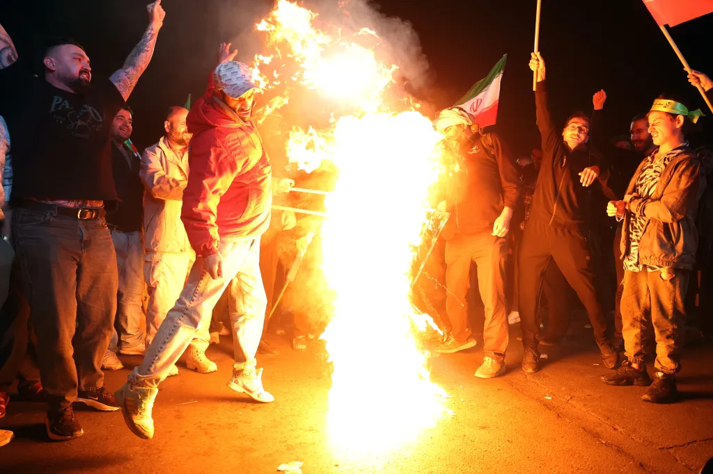 Iranians burn U.S. and Israeli flags during a demonstration in Tehran following a ceasefire announcement.