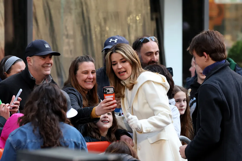 Savannah Guthrie taking a selfie with a fan in the crowd.