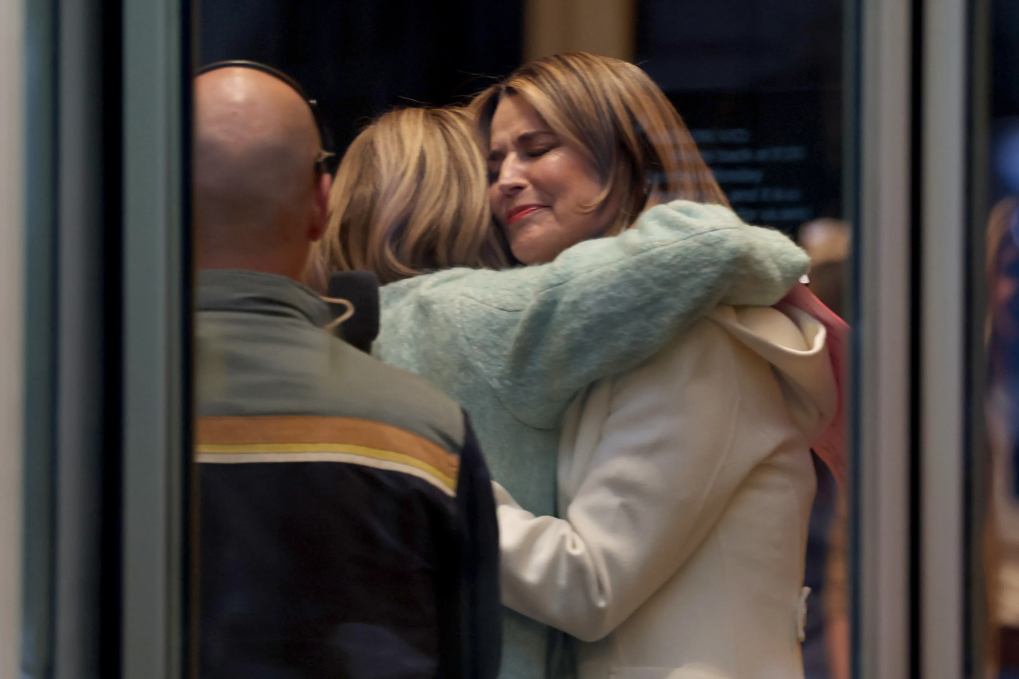 Savannah Guthrie is embraced by a colleague while visibly emotional.