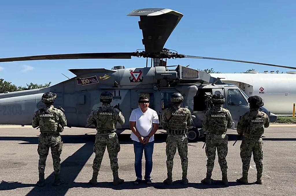 This handout picture released by the Mexican Secretariat of National Defense shows Audias Flores Silva (3rd-L), one of the closest allies of Nemesio "El Mencho" Oseguera, leader of the CNJG cartel, next to Mexican Navy soldiers in the Western state of Nayarit, Mexico, on April 27, 2026. 