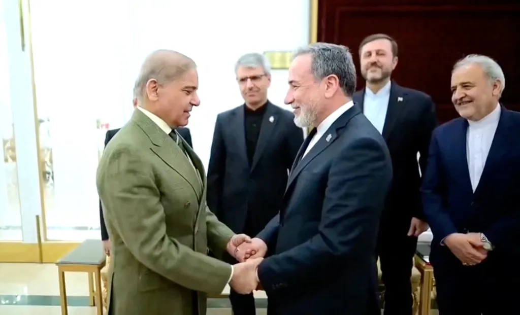 Iranian Foreign Minister Abbas Araqchi shakes hands with Pakistani Prime Minister Shehbaz Sharif.