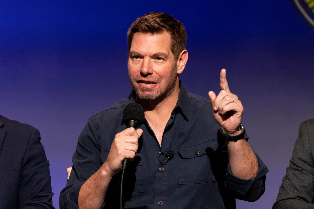 US Representative Eric Swalwell speaking into a microphone and gesturing.