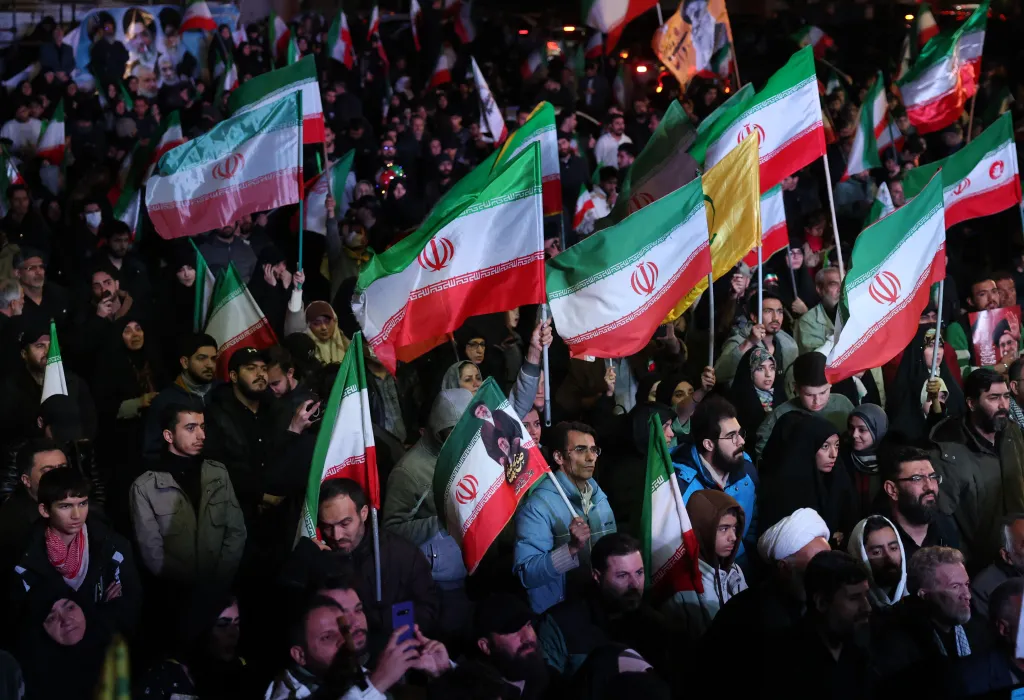 Crowd of Iranians holding Iranian flags at Enqelab Square in Tehran.
