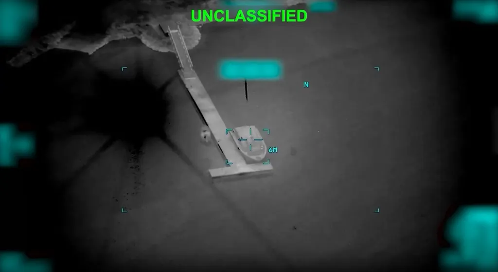 Infrared drone footage shows an Iranian mine-laying vessel being targeted by a projectile near the Strait of Hormuz.