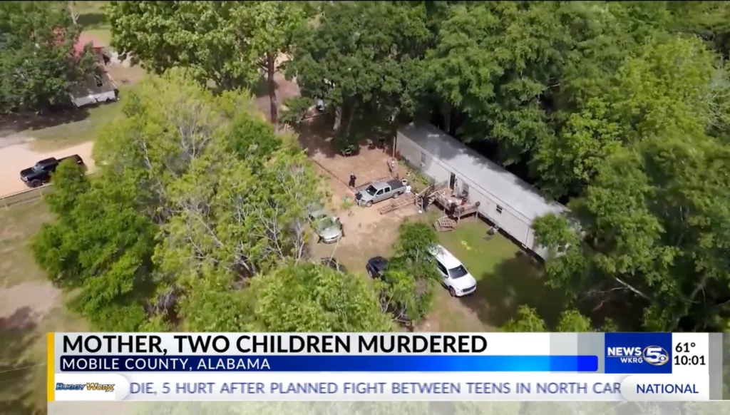 Aerial view of a mobile home surrounded by trees and cars, with text overlay "MOTHER, TWO CHILDREN MURDERED MOBILE COUNTY, ALABAMA."