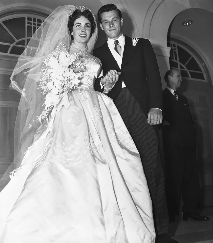 Elizabeth Taylor and Conrad Hilton Jr. holding hands after their wedding at the Church of the Good Shepherd in Beverly Hills.