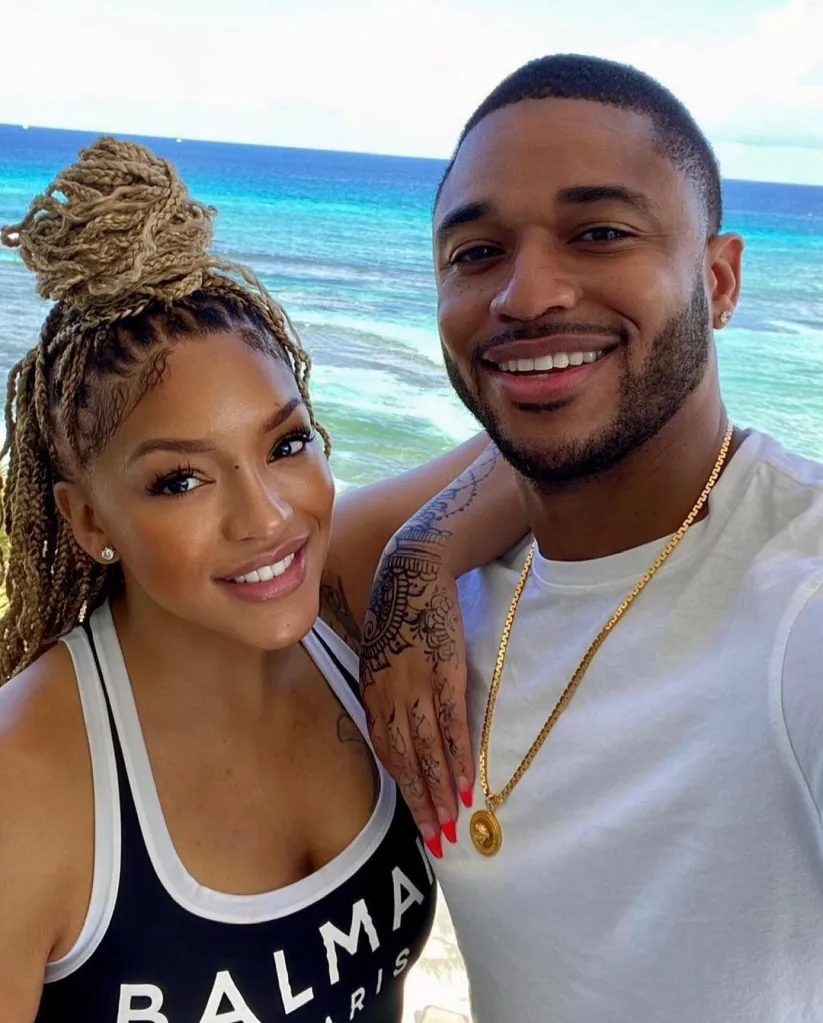 A man and a woman posing for a selfie in front of the ocean.
