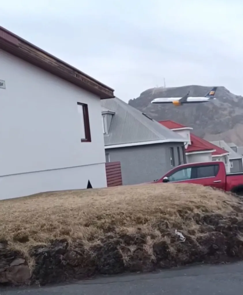 Plane flying low over buildings.