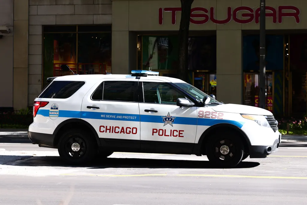 A white Chicago Police vehicle with a blue stripe and 
