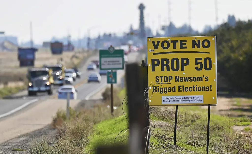 A yellow sign on the side of a road that reads 