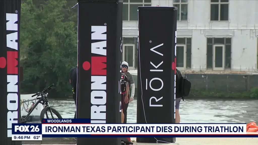 A screenshot of a news report with the headline "IRONMAN TEXAS PARTICIPANT DIES DURING TRIATHLON" overlaid on an image of people and triathlon banners.
