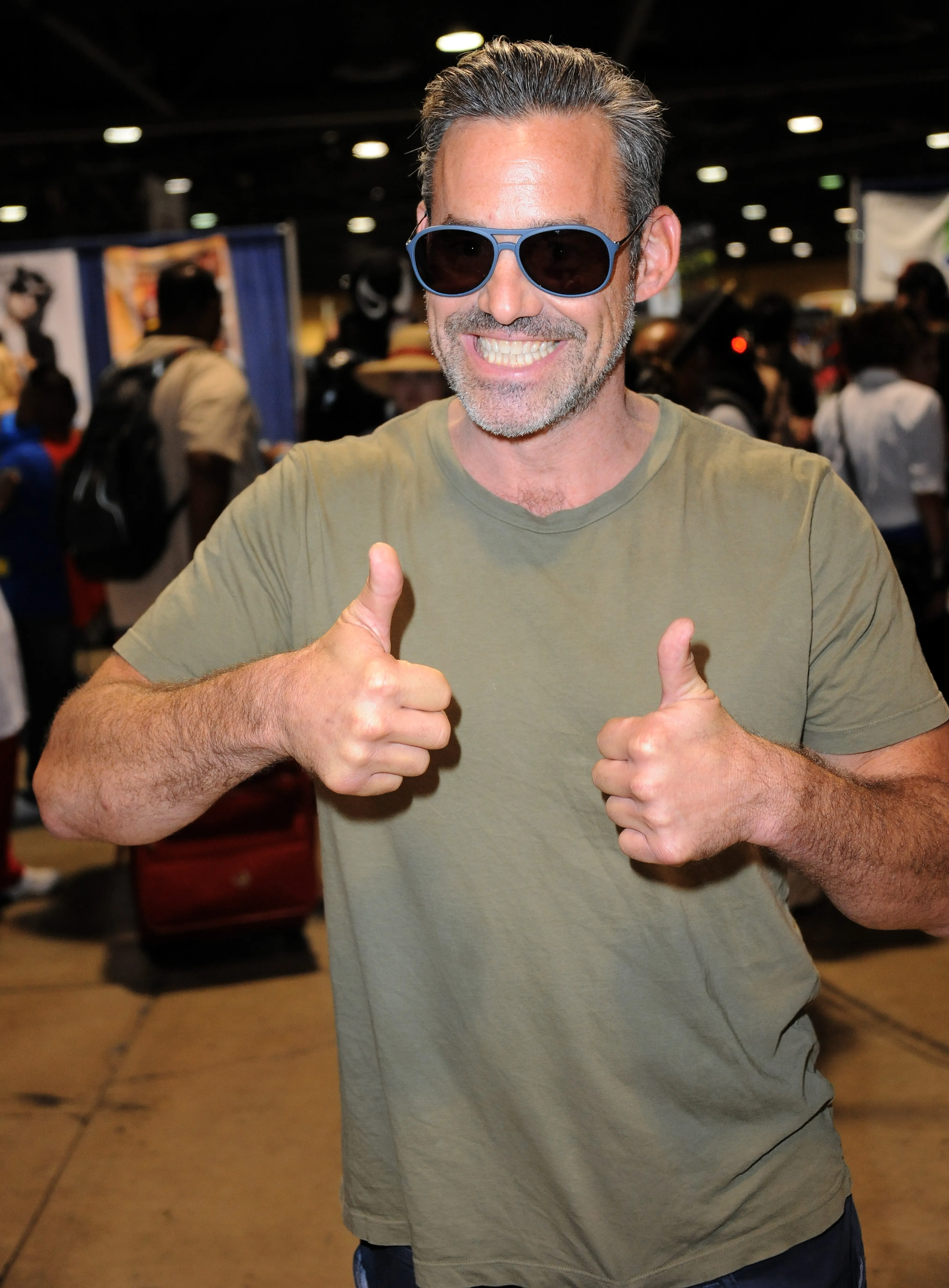 Nicholas Brendon in a t-shirt and sunglasses gives two thumbs up.