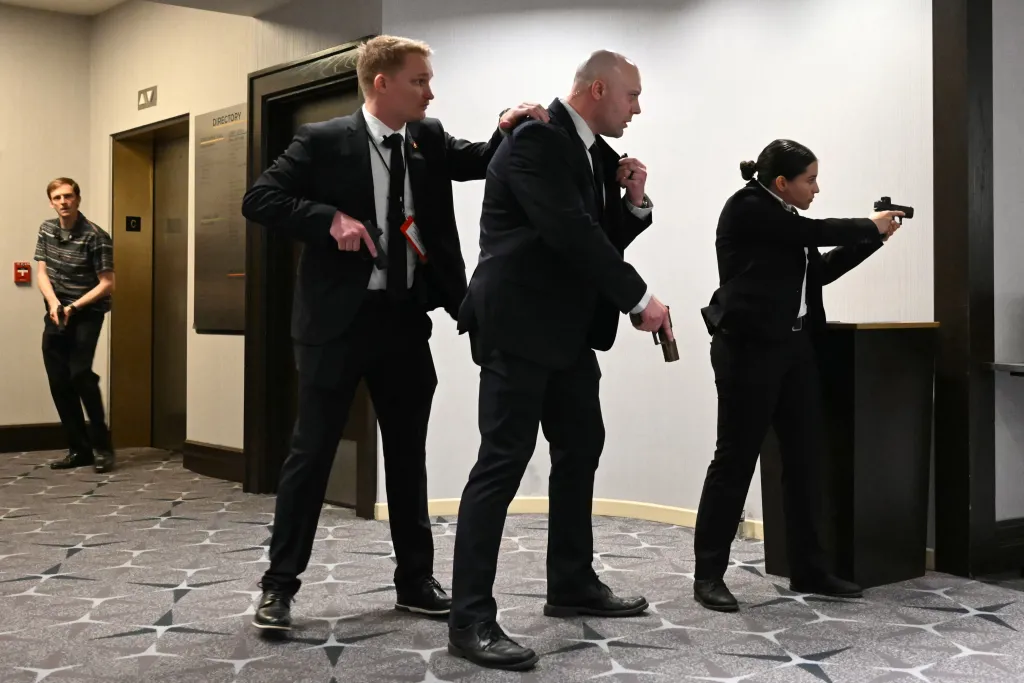 Three secret service agents drawing their guns after hearing loud noises at the Washington Hilton hotel.