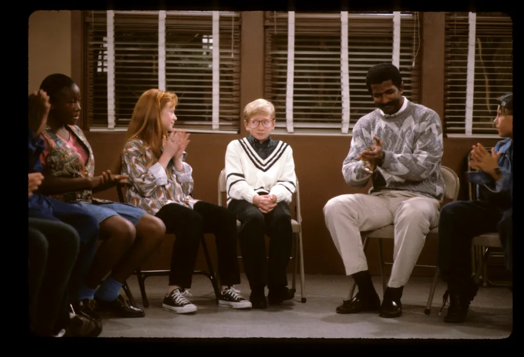Natanya Ross, Christopher Castile, and Rif Hutton sitting and clapping with others.