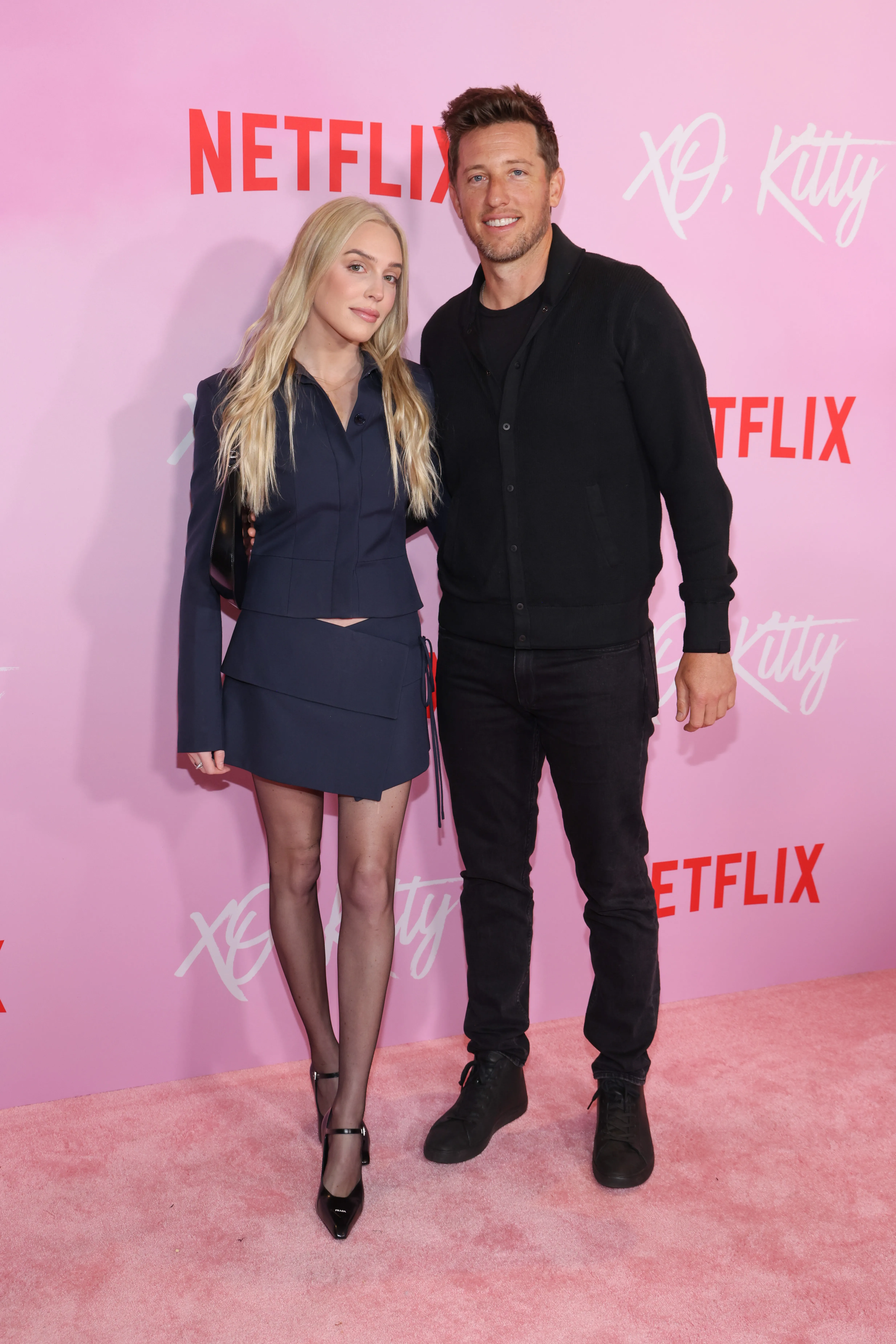 Alex Cooper and Matt Kaplan on a pink carpet at the "XO, Kitty" premiere.