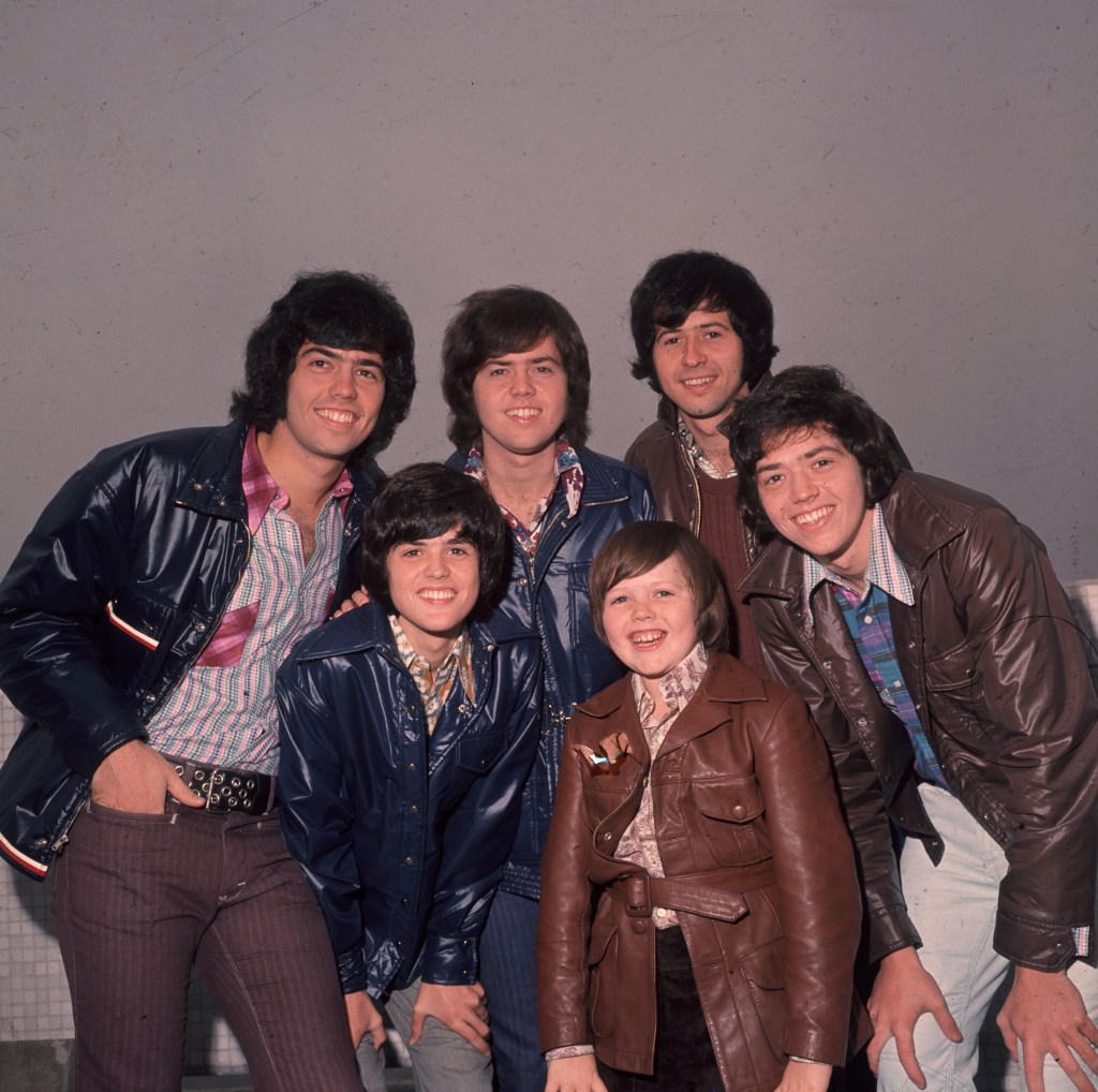 The Osmonds, a vocal pop group of six young men and boys, posing for a photo.